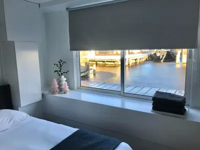 a bedroom with a window with a view of a dock at Quiet Waterloft near Amsterdam and Schiphol WS11 in Aalsmeer