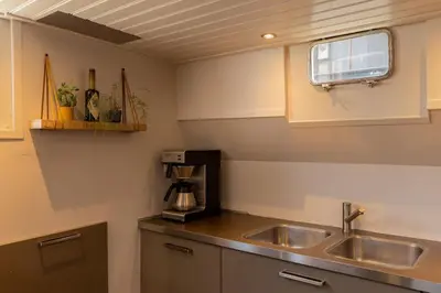 a kitchen with a sink and a coffee maker at Boutique style ship 10 double cabins in Monnickendam