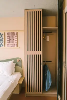 a door to a bedroom with a bed and a closet at Hotel Jansen Amsterdam Bajeskwartier in Amsterdam
