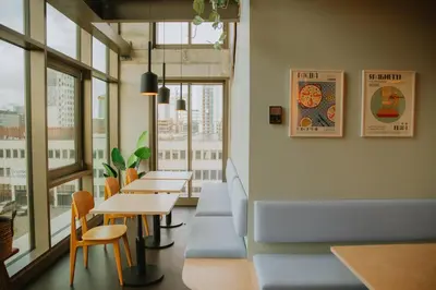 a restaurant with tables and chairs and windows at Hotel Jansen Amsterdam Bajeskwartier in Amsterdam