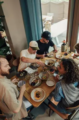 a group of people sitting around a table eating food at Hotel Jansen Amsterdam Bajeskwartier in Amsterdam