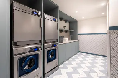 a kitchen with two washing machines in a room at Citadines Canal Amsterdam in Amsterdam
