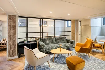 a living room with a couch and chairs at Citadines Canal Amsterdam in Amsterdam