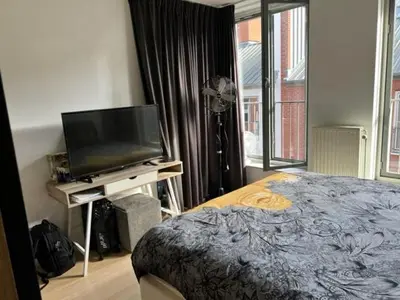 a bedroom with a bed and a flat screen tv at center appartement 2 rooms in Alphen aan den Rijn