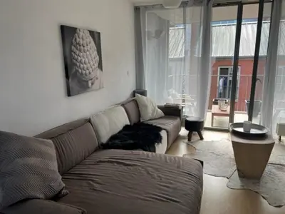 a living room with a couch and a large window at center appartement 2 rooms in Alphen aan den Rijn