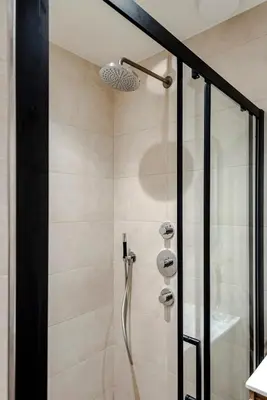 a bathroom with a shower with a glass door at Dunefront Apartment in Zandvoort