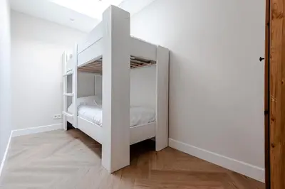 a white bunk bed in a white room at Dunefront Apartment in Zandvoort