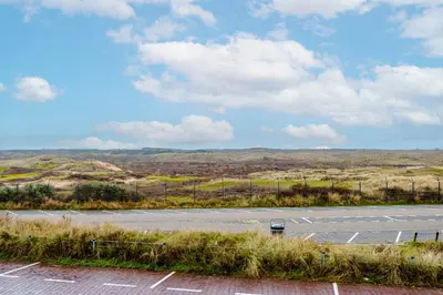 a parking lot with a car parked on the side of a road at Dunefront Apartment in Zandvoort
