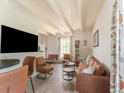 a living room with a couch and chairs and a tv at Farmhouse with terrace in Montfoort in Montfoort