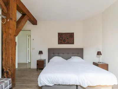 a bedroom with a large bed with white sheets at Farmhouse with terrace in Montfoort in Montfoort
