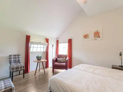 a bedroom with a bed and a chair at Farmhouse with terrace in Montfoort in Montfoort