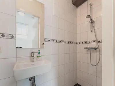 a white bathroom with a sink and a shower at Farmhouse with terrace in Montfoort in Montfoort