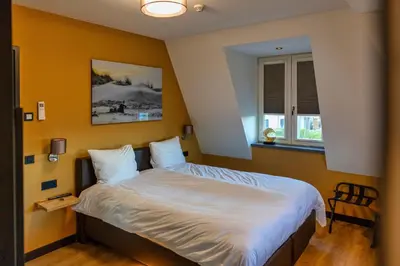 a bedroom with a large bed with white sheets at Villa Savannah in Roelofarendsveen