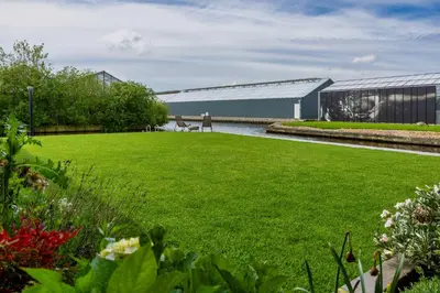 a garden with a green lawn and a building at Villa Savannah in Roelofarendsveen