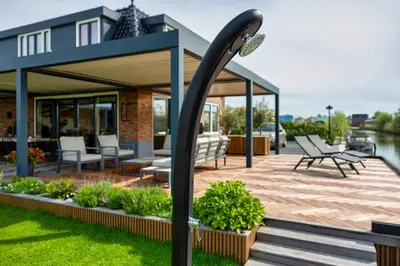 a house with a deck with chairs and a light pole at Villa Savannah in Roelofarendsveen