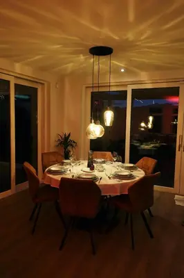 a dining room table with chairs and aendant light at Villa Savannah in Roelofarendsveen