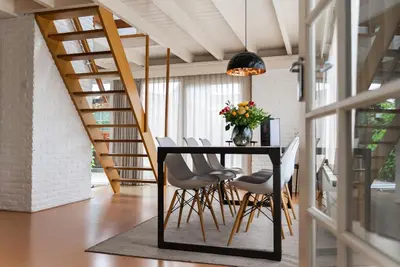 a dining room with a black table and chairs at - Het Kleine Nest - nabij het meer, strand & Keukenhof in Noordwijkerhout