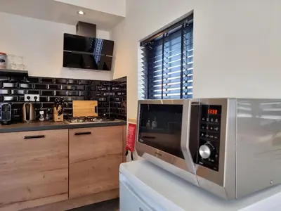 a kitchen with a microwave on a counter at ZeeZuid in Egmond aan Zee