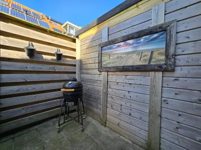 a grill and a picture hanging on a wall at ZeeZuid in Egmond aan Zee