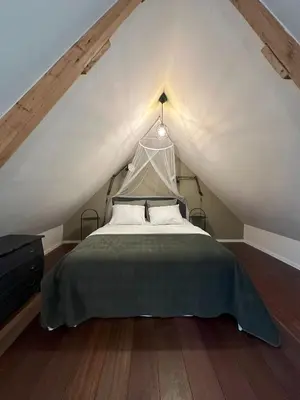 a bedroom with a bed in a attic at Boutique appartement vlak bij Amsterdam in Rijnsaterwoude
