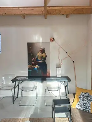 a table in a living room with a painting on the wall at Boutique appartement vlak bij Amsterdam in Rijnsaterwoude