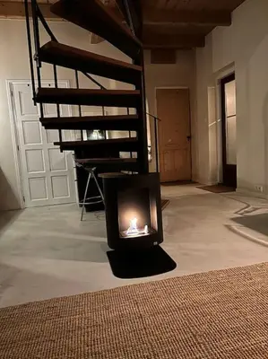 a fireplace in a living room with a staircase at Boutique appartement vlak bij Amsterdam in Rijnsaterwoude