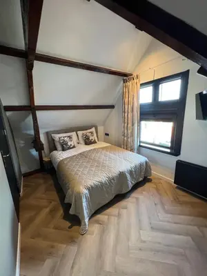 a bedroom with a bed and a large window at Boutique Hotel de Kade Zaandam-Amsterdam in Zaandam