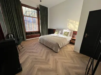 a bedroom with a bed and a large window at Boutique Hotel de Kade Zaandam-Amsterdam in Zaandam
