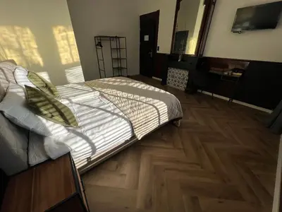 a bedroom with a bed and a wooden floor at Boutique Hotel de Kade Zaandam-Amsterdam in Zaandam