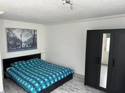 a bedroom with a bed and a painting on the wall at Zaandam Cottage Centre - Zaanse Schans Amsterdam in Zaandam
