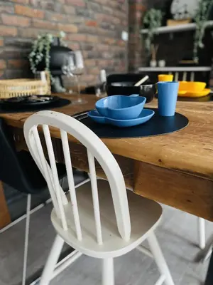 a white chair sitting in front of a wooden table at By Balu in Soest