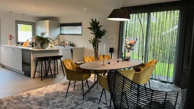 a kitchen and dining room with a table and chairs at VILLA ARYVE in See-, Strand- und Golfplatznähe inklusive NETFLIX, Bad en Suite und Wohlfühlgarantie in Dirkshorn