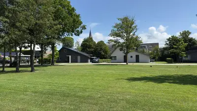 a field of grass with trees and a building at VILLA ARYVE in See-, Strand- und Golfplatznähe inklusive NETFLIX, Bad en Suite und Wohlfühlgarantie in Dirkshorn