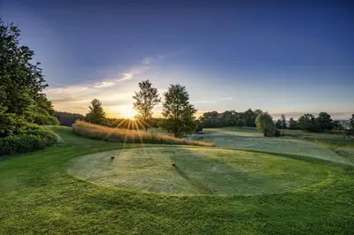 an overhead view of a golf green with the sun setting at VILLA ARYVE in See-, Strand- und Golfplatznähe inklusive NETFLIX, Bad en Suite und Wohlfühlgarantie in Dirkshorn