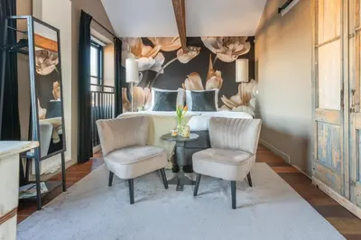 a bedroom with a bed and two chairs and a table at Bed and Breakfast Geliefd in Voorhout
