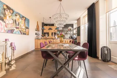 a dining room with a table and chairs at Bed and Breakfast Geliefd in Voorhout