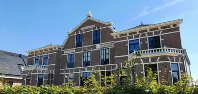 a large brick building with windows on the side of it at Bed and Breakfast Geliefd in Voorhout