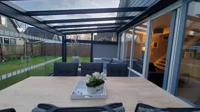a patio with a wooden table and chairs and glass doors at villachiller in Sint Maarten