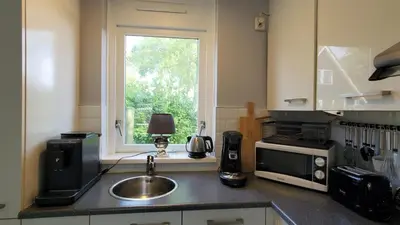 a kitchen with a sink and a microwave and a window at villachiller in Sint Maarten