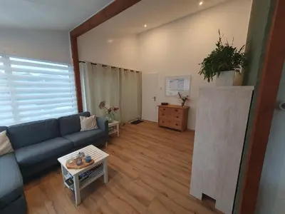 a living room with a blue couch and a table at Rekerlanden 117 in Schoorldam
