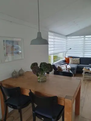 a living room with a wooden table and chairs at Rekerlanden 117 in Schoorldam