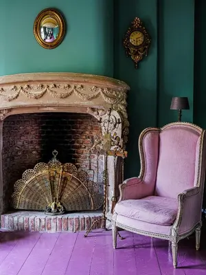 a living room with a fireplace and a chair at Private and chique Salon de Franz in Amsterdam