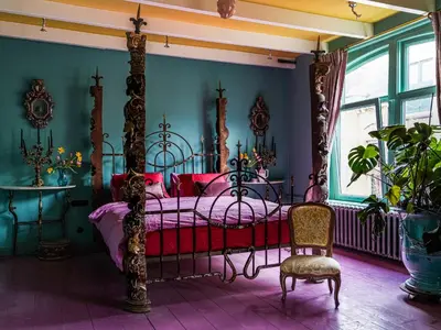 a bedroom with a canopy bed and a chair at Private and chique Salon de Franz in Amsterdam