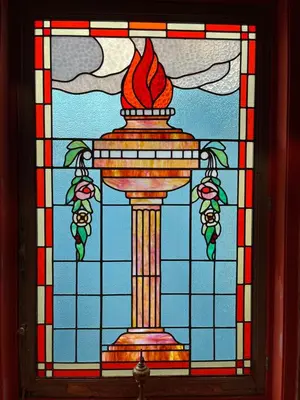 a stained glass window with a column with a fire at Private and chique Salon de Franz in Amsterdam