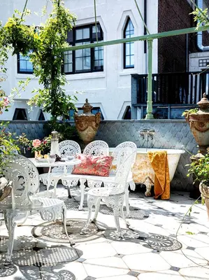 a patio with white chairs and a table and a fountain at Private and chique Salon de Franz in Amsterdam