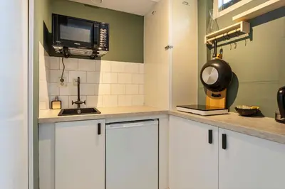 a kitchen with white cabinets and a microwave at B&B Hendricus in Hoofddorp