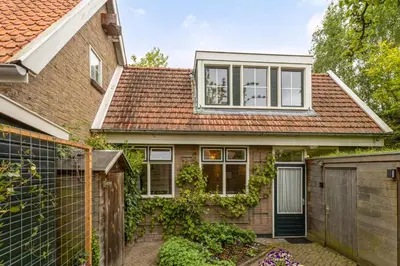 a house with a brown roof and a fence at B&B Hendricus in Hoofddorp