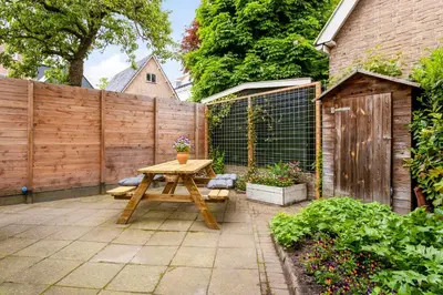 a patio with a picnic table and a fence at B&B Hendricus in Hoofddorp