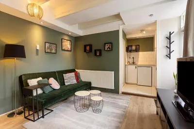 a living room with a green couch and a table at B&B Hendricus in Hoofddorp