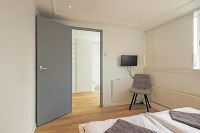 a bedroom with a mirror and a purple chair at Zon Modern beach house in Bergen aan Zee
